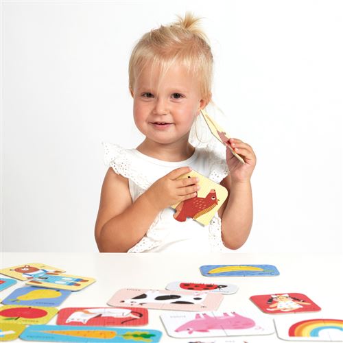 Criança com cartas de jogo coloridas sentada à mesa