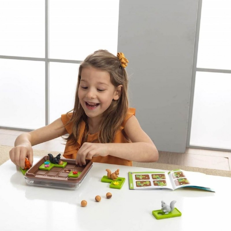 Menina a jogar com um jogo de tabuleiro com peças de animais numa mesa branca