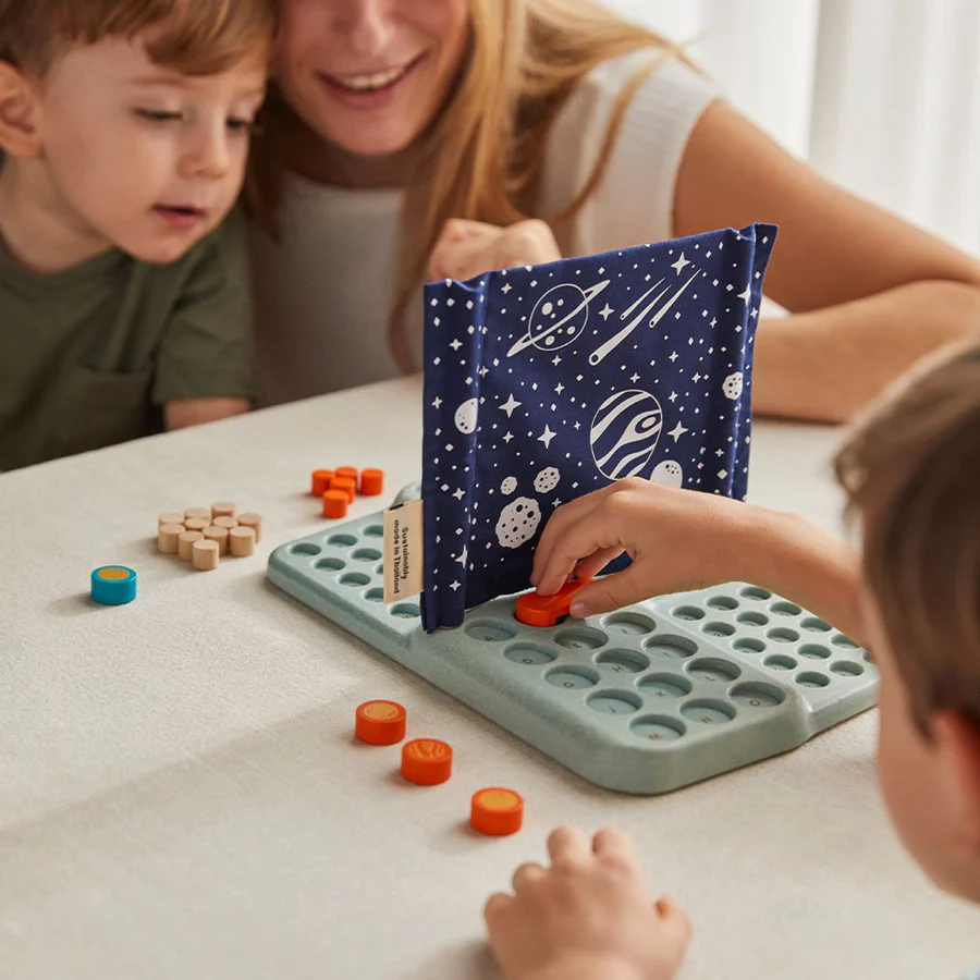 Conjunto de jogo de mesa com tabuleiro verde, peças coloridas e divisor azul com desenho espacial.