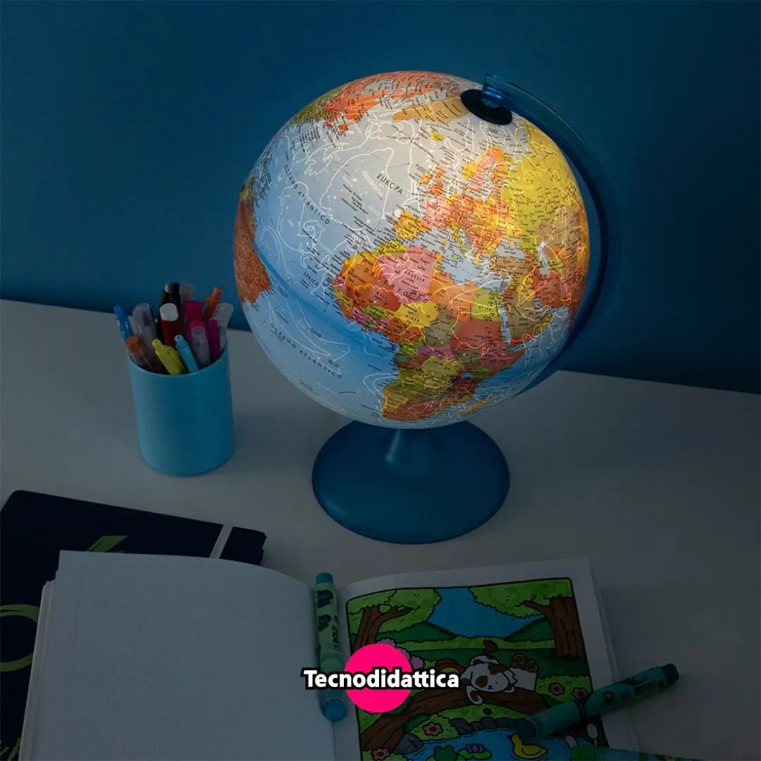 Globo terrestre colorido com base azul e materiais de desenho sobre mesa branca