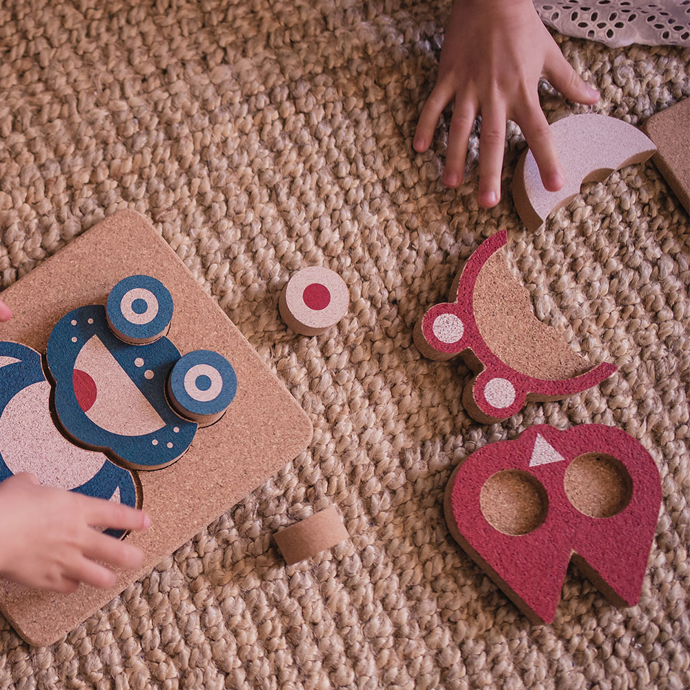 Peças de madeira coloridas para montagem sobre tapete de fibra natural com mãos de criança