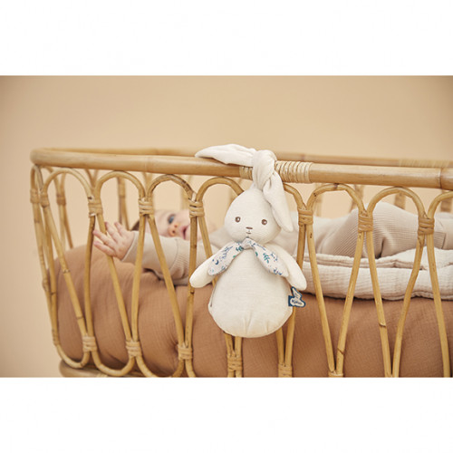 Berço de rattan com peluche de coelho branco pendurado