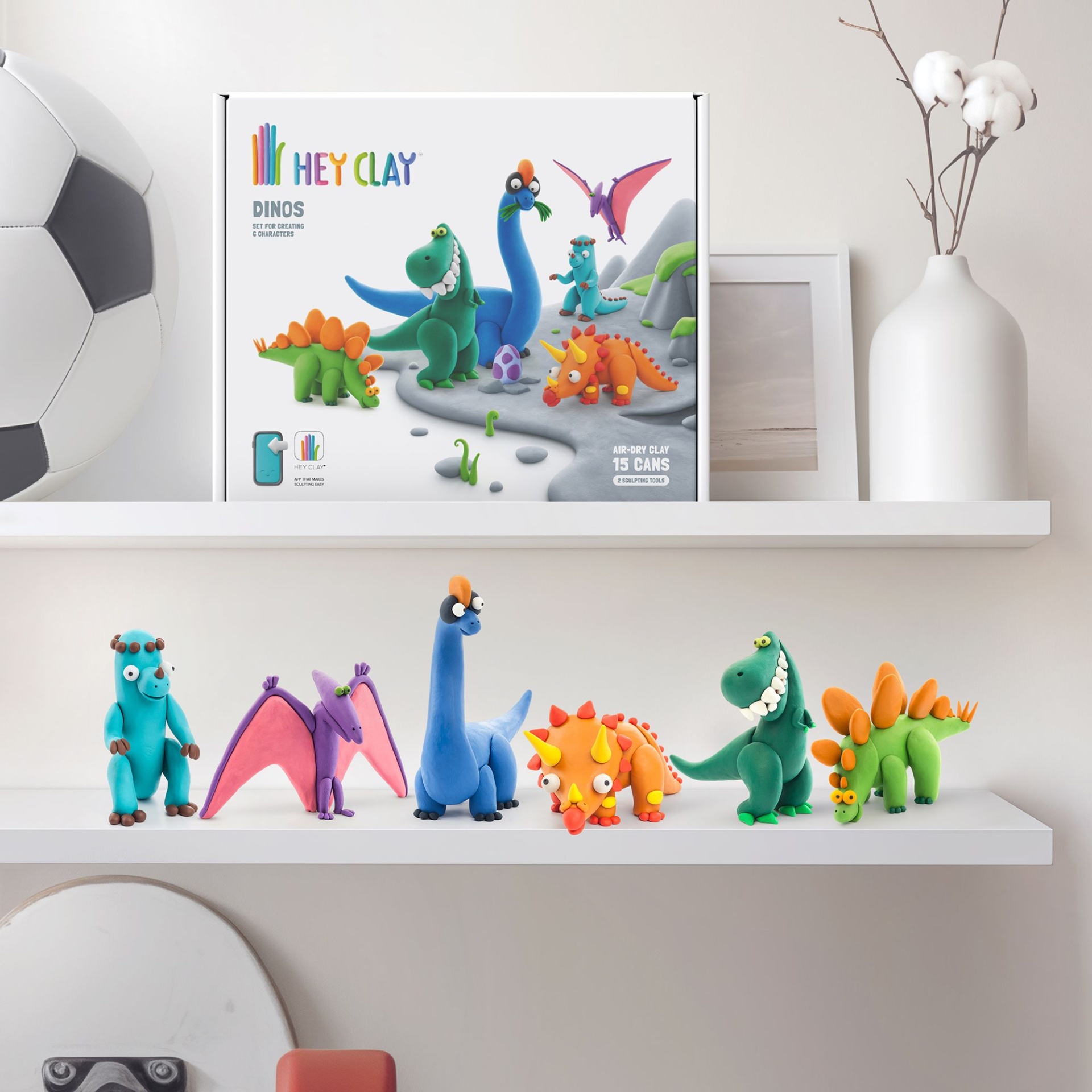 Conjunto de modelagem HEY CLAY DINOS com figuras de dinossauros coloridos e acessórios numa prateleira branca