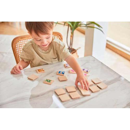 Criança a jogar com peças de madeira num jogo de memória