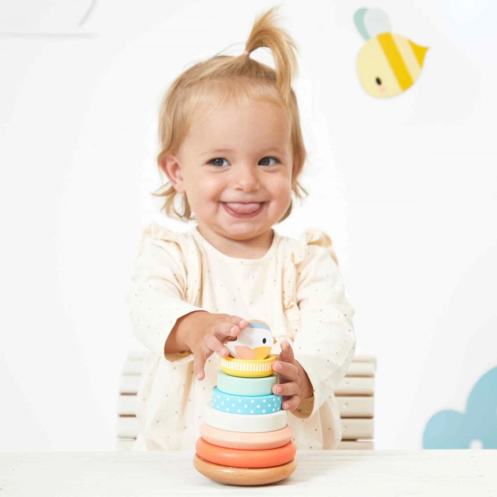 Criança pequena brincando com brinquedo de empilhar de madeira colorido