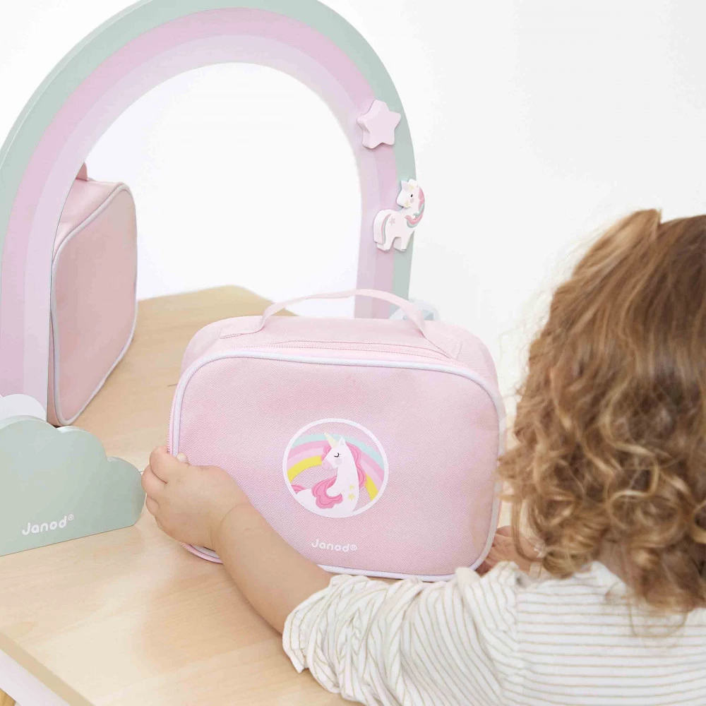 Mala rosa com unicórnio e a marca Janod numa mesa com espelho decorado