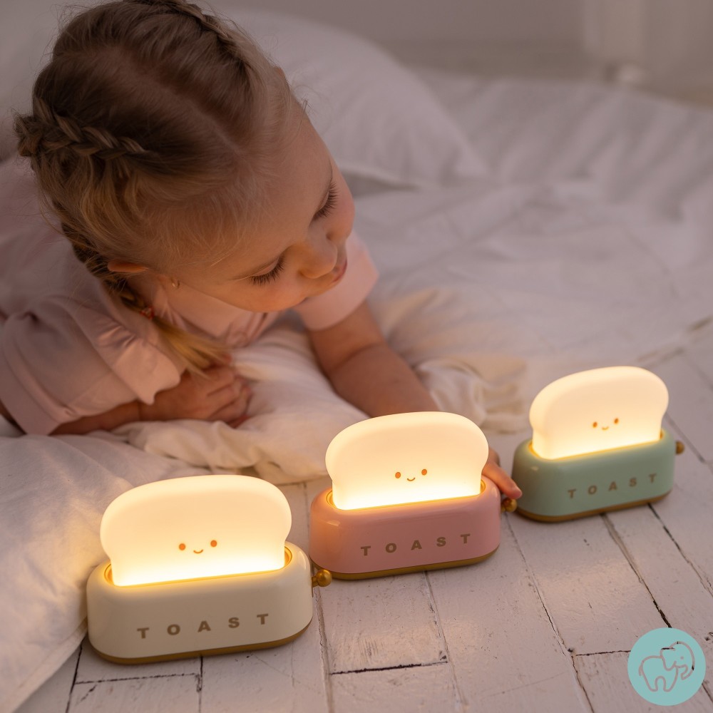 Três luzes de mesa em forma de pão sorridente com bases coloridas e criança a olhar