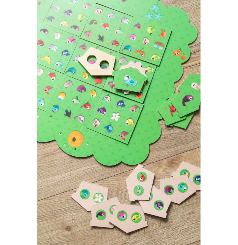 Jogo de tabuleiro verde com peças de madeira ilustradas e buracos circulares sobre mesa de madeira