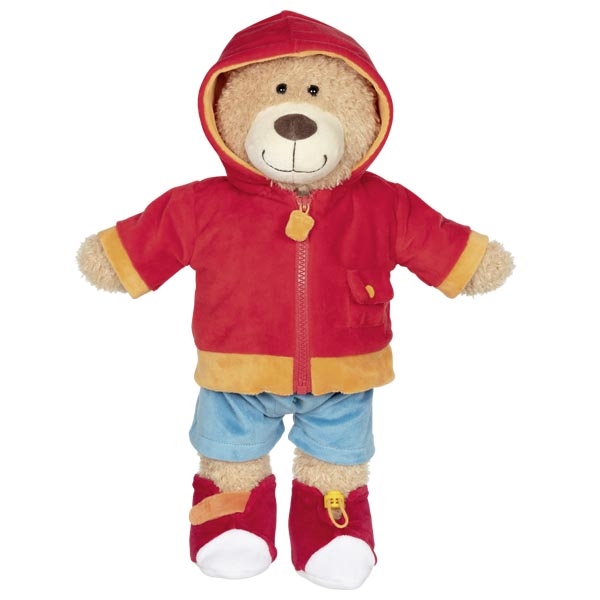 Urso de peluche vestido com casaco vermelho, calças azuis e sapatinhos vermelhos e brancos
