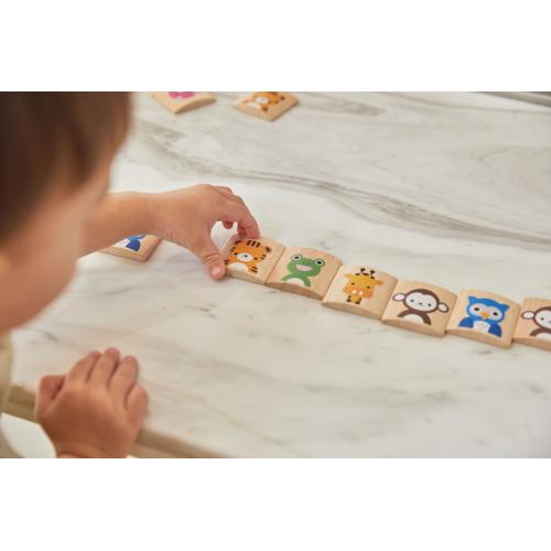 Peças de madeira com desenhos de animais coloridos dispostas em linha sobre mesa de mármore