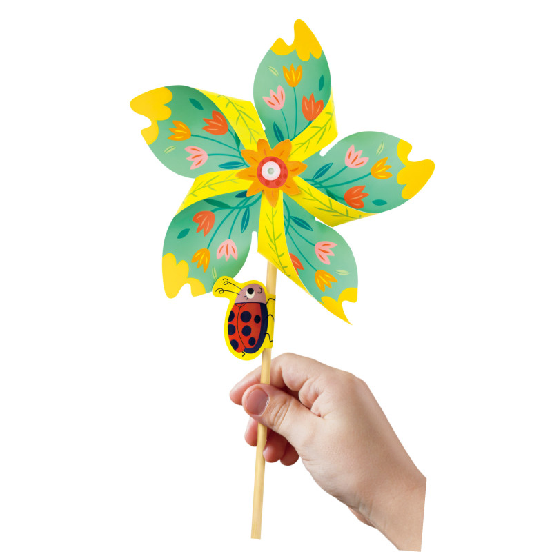 Moinho de vento colorido com flores e joaninha, segurado por uma mão