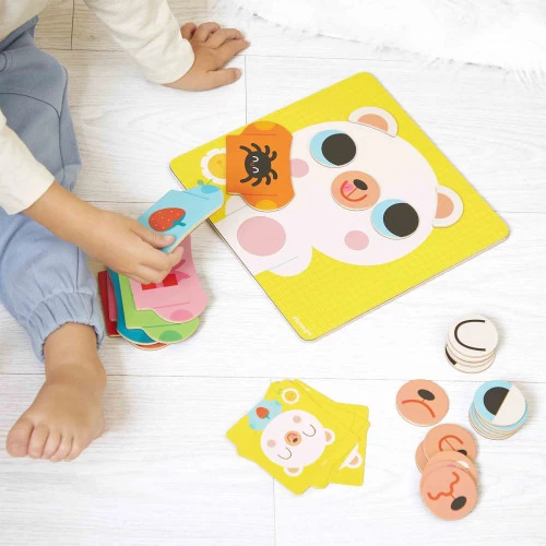 Criança a brincar com jogo educativo de cartas coloridas no chão de madeira clara