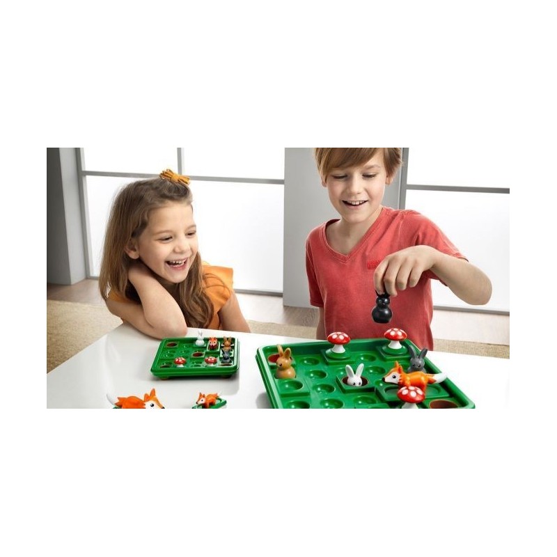 Crianças a jogar jogo de tabuleiro verde com peças de animais e cogumelos