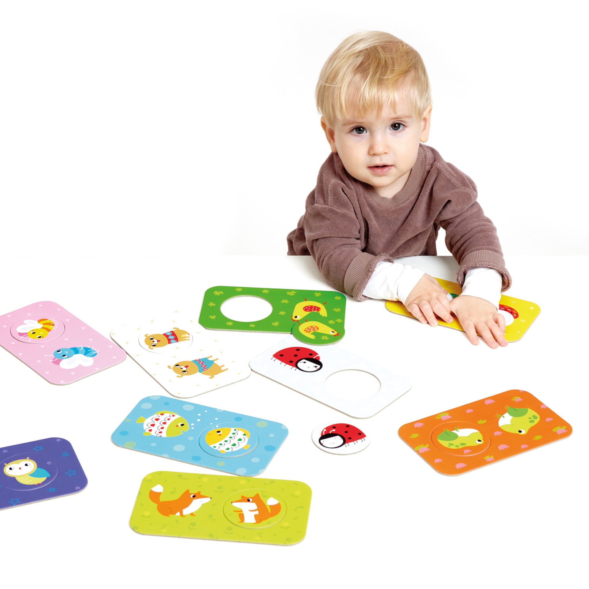 Criança com peças para encaixe coloridas com desenhos de animais e insetos