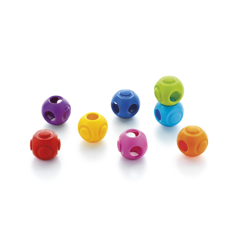 Bolas coloridas de plástico com buracos circulares e relevo em superfície branca