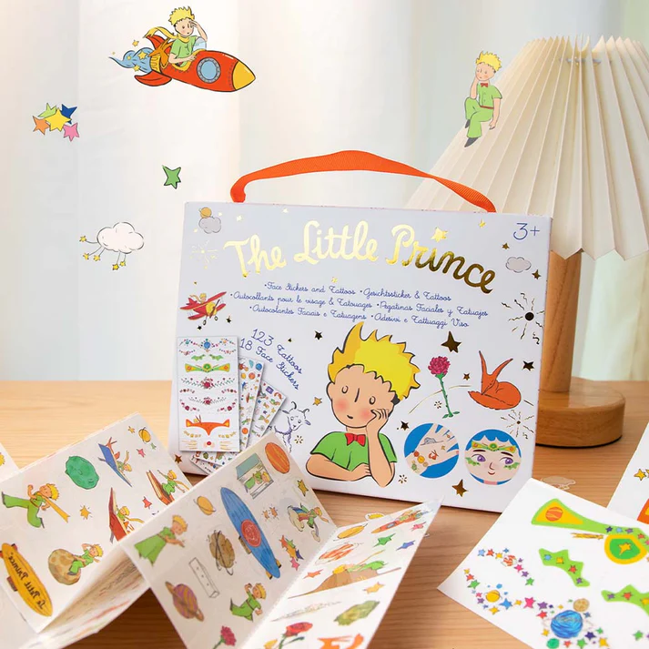 Conjunto de tatuagens e adesivos The Little Prince em caixa branca com alça laranja e ilustrações coloridas