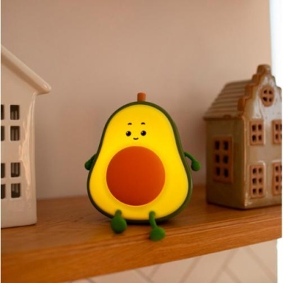 Figura decorativa de abacate com rosto sentado numa prateleira de madeira