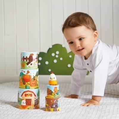 Brinquedo empilhável com peças coloridas e bebé a brincar