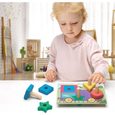 Criança loira a brincar com brinquedo de madeira colorido com formas geométricas