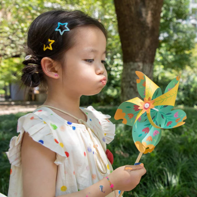Criança segurar brinquedo catavento colorido em ambiente exterior