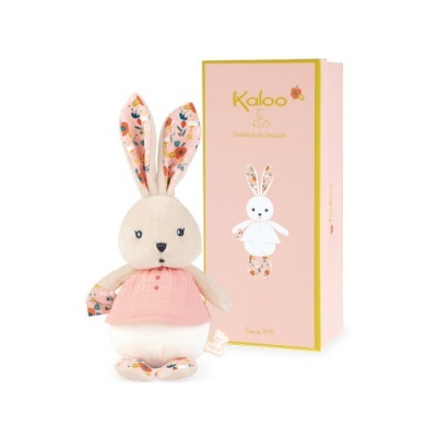 Coelhinho de peluche com padrão floral e vestido rosa ao lado de caixa Kaloo