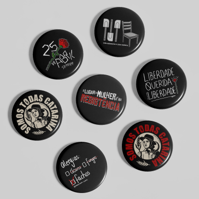 Bottons redondos pretos com frases e desenhos em várias cores.