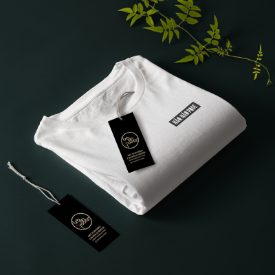 T-shirt branca dobrada com estampa e etiqueta Urban Roots num fundo escuro com folhas verdes