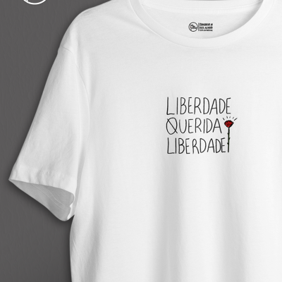 T-shirt branca com texto e flor estampados.