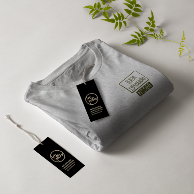 T-shirt cinzenta dobrada com etiqueta preta e texto impresso verde