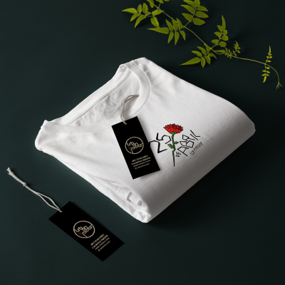 T-shirt branca dobrada com estampa de rosa vermelha e texto 25 DE ABRIL SEMPRE!