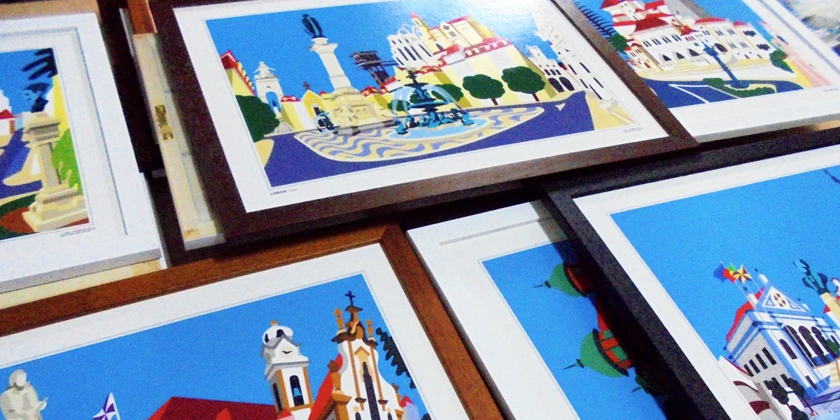 Quadros com ilustrações urbanas coloridas em molduras de madeira castanha e branca