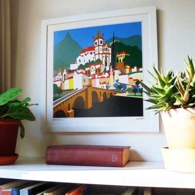 Quadro colorido de vila e estante com livro e plantas