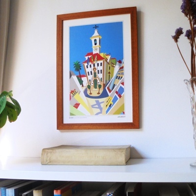 Quadro ilustrativo de edifício colorido com moldura de madeira pendurado na parede