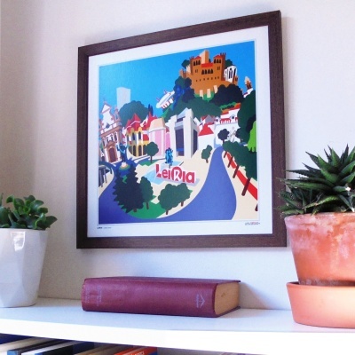 quadros ilustrando a cidade de Leiria emoldurado na parede com livro e plantas na prateleira