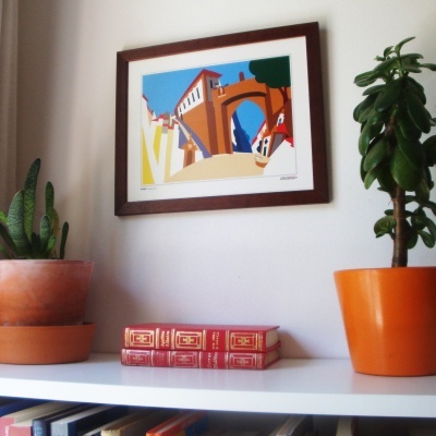 Estante branca com livros, plantas em vasos e pintura colorida emoldurada