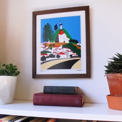 Quadro colorido de paisagem com moldura castanha e estante com livros e plantas