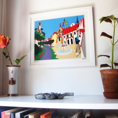 Quadro branco com ilustração colorida de uma praça, estante branca com livros, pedra cinza e flores em vasos