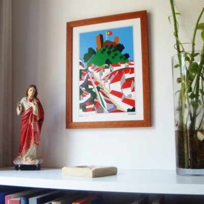 Estante branca com estatueta religiosa, livro pequeno, vaso com plantas e quadro com ilustração colorida de castelo.