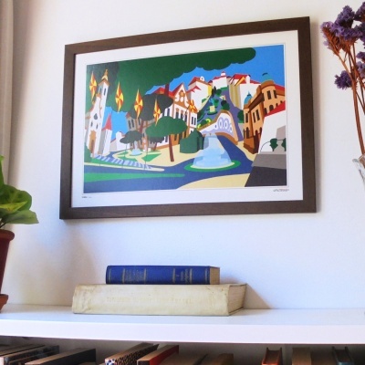 Gravura colorida de paisagem urbana em quadro castanho na parede