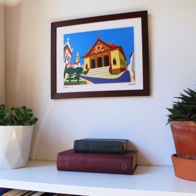 Quarto com quadro colorido, livros empilhados e plantas em vasos