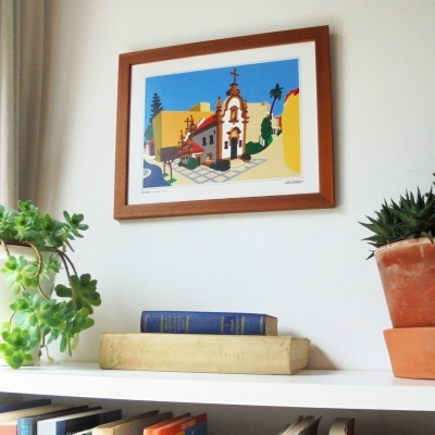 Quadro com ilustração colorida de capela e plantas sobre estante com livros e vasos.