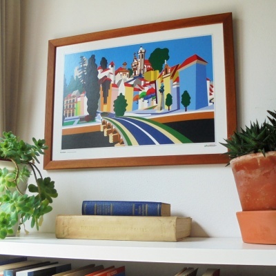 Decoração com moldura de madeira, impressão colorida, plantas em vasos e livros em prateleira branca