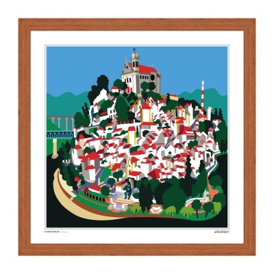 Serigrafia colorida de uma cidade com casas brancas de telhados vermelhos e edifício grande ao fundo, moldurada em madeira