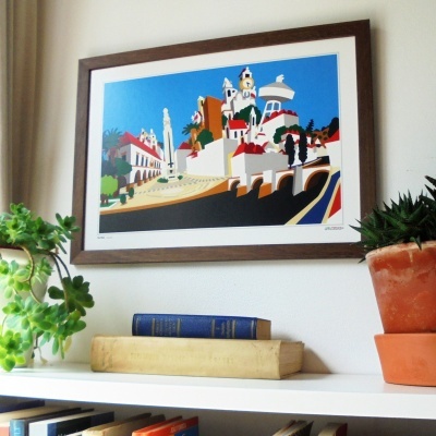 Quadro decorativo com paisagem urbana colorida e moldura em madeira na parede