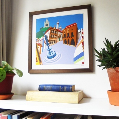 Quadro emoldurado com imagem colorida de cidade e prateleira com livros e plantas