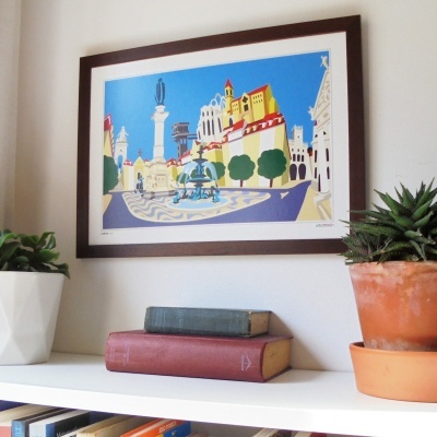 Impressão artística emoldurada sobre prateleira com plantas e livros