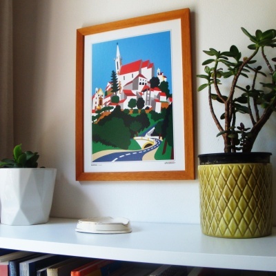 Estante com vasos de plantas e quadro colorido de vila