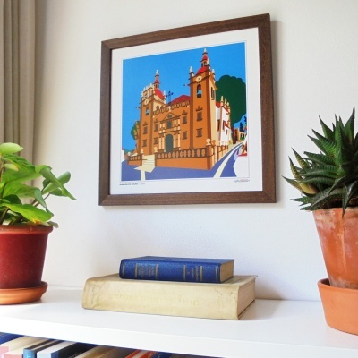 Estante com plantas, livros e quadro emoldurado com ilustração de edifício histórico