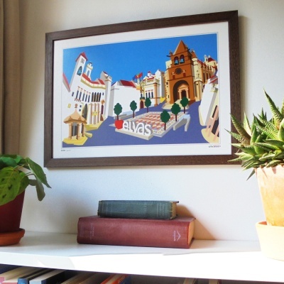 quadro emoldurado com arte de edifícios e palavra 'elvas' pendurado na parede acima de prateleira com plantas e livros