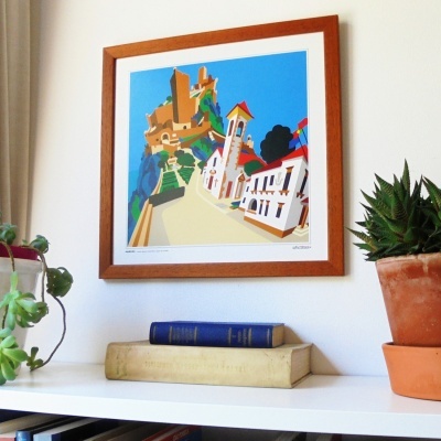 Estante branca com livros, plantas e quadro colorido em moldura de madeira